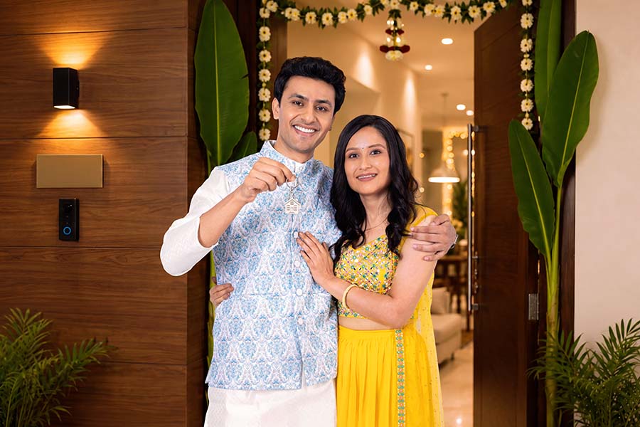 Indian couple proudly displaying new house key after home purchase