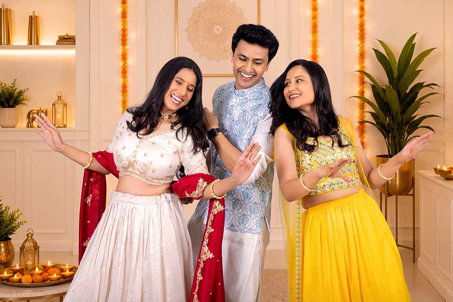 Happy Indian friends enjoying festive dance during Diwali party