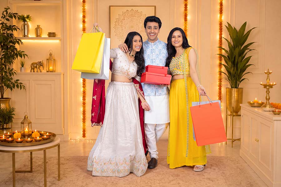 Young Indian friends celebrating Diwali with gifts and shopping bags at home