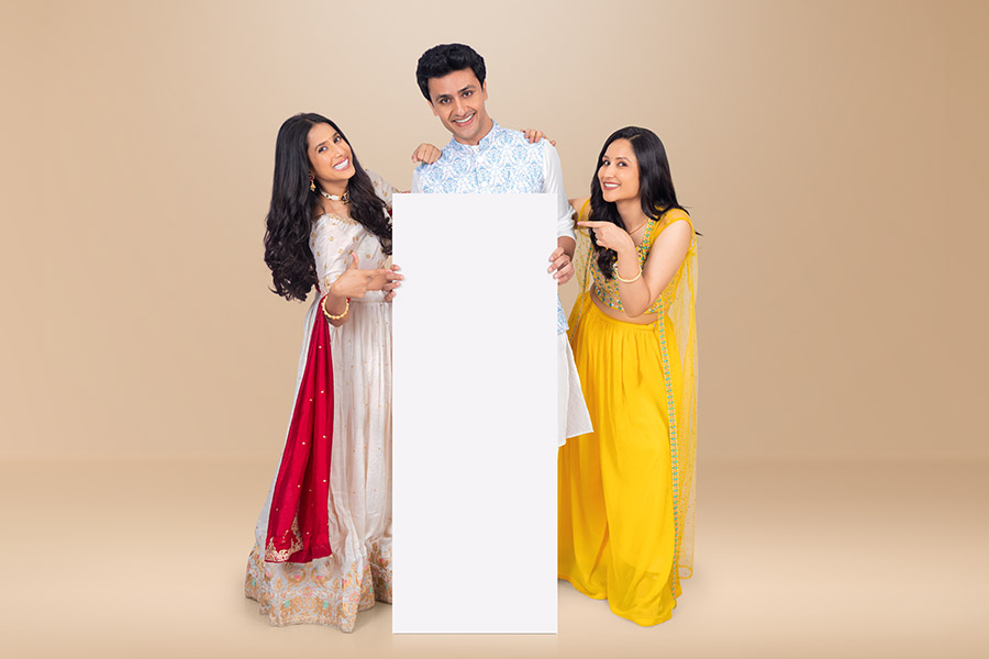 Indian friends and couple presenting blank promotional display during Diwali