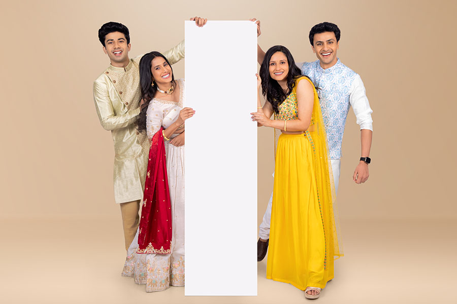 Indian friends presenting blank vertical advertising display for festive campaign