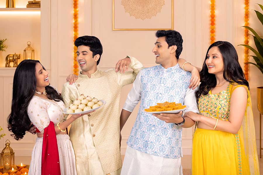 Indian friends enjoying Diwali sweets together during festive celebration
