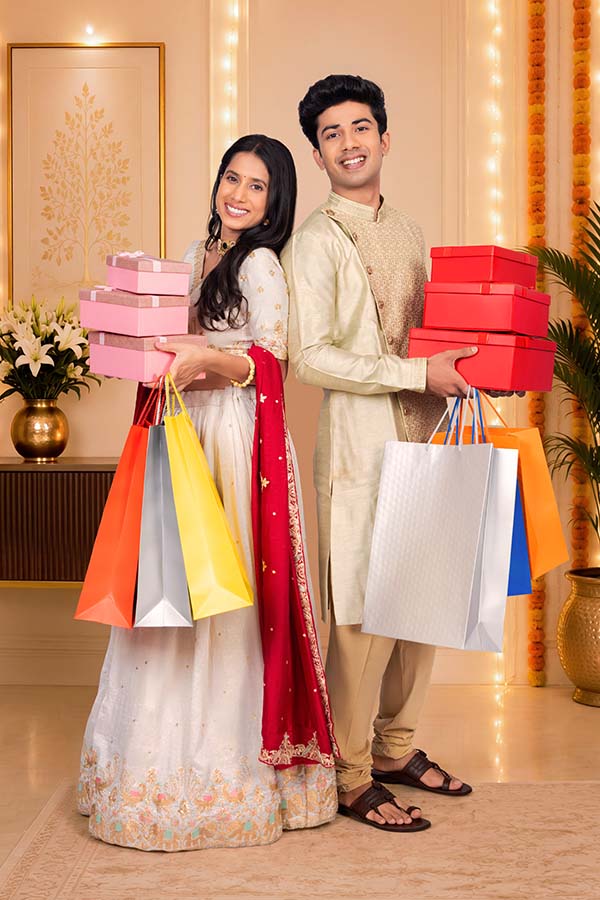 Indian couple carrying shopping bags and festive gift boxes