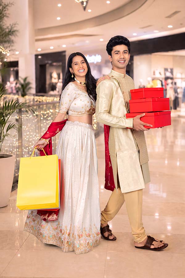 Smiling Indian couple carrying festive shopping bags and gifts