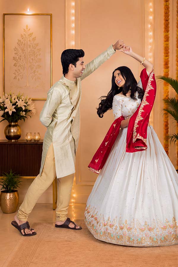 Young Indian couple dancing together during Diwali celebration at home