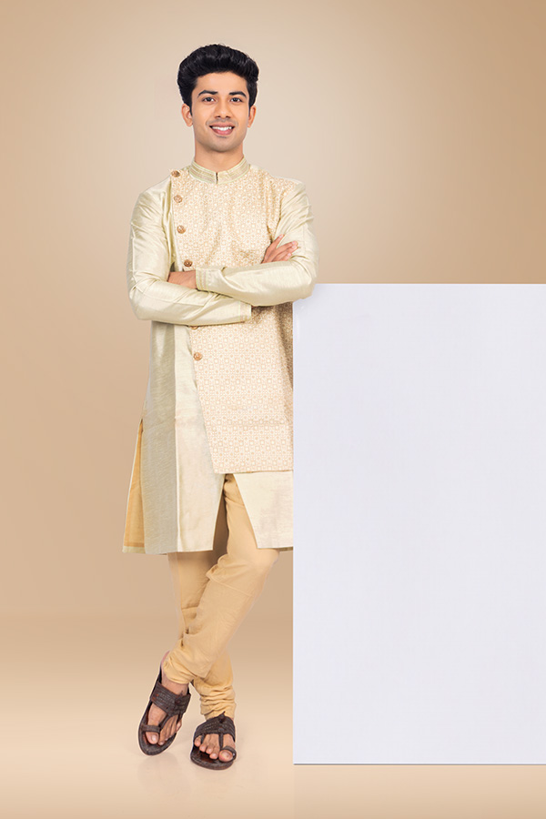 Indian man leaning on blank display board in festive attire