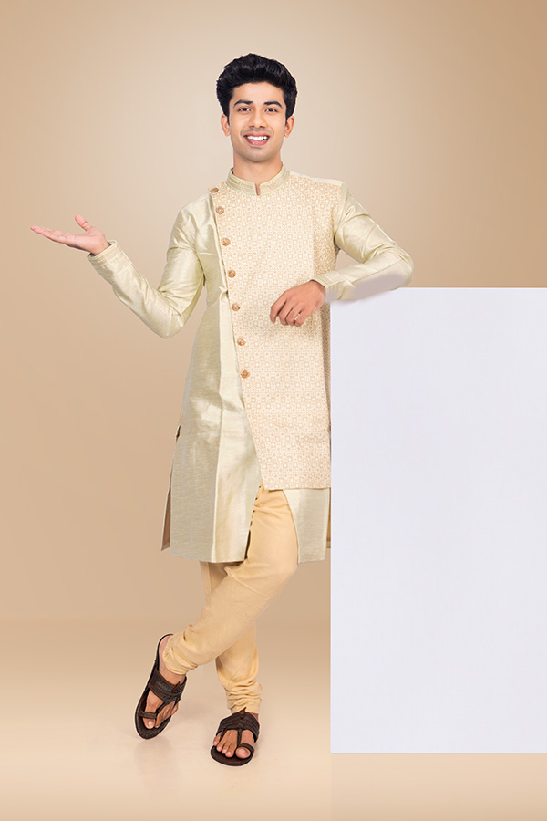 Young Indian man presenting blank display board in festive ethnic attire
