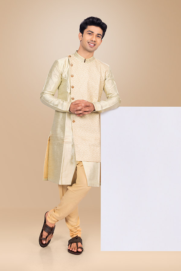 Elegant Indian man leaning on blank advertising panel in ethnic wear