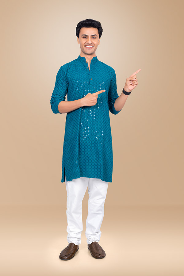 Indian man pointing towards copy space in festive blue kurta