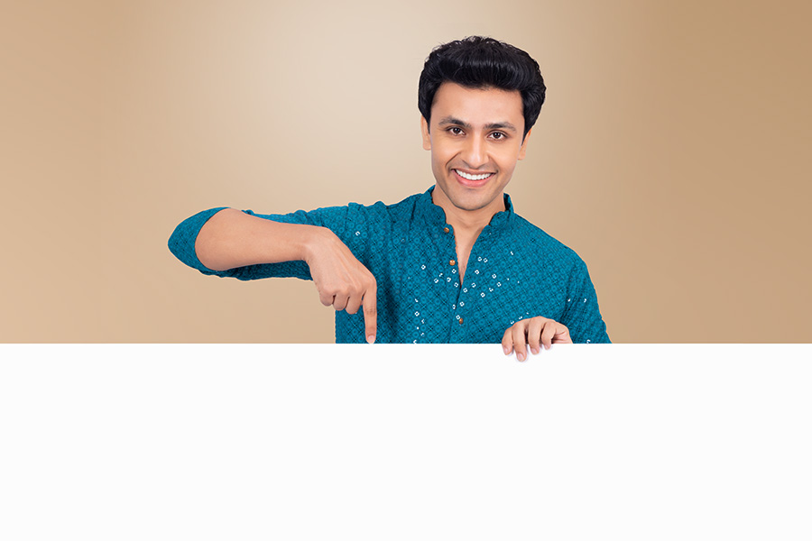 Indian man indicating empty promotional banner in traditional kurta