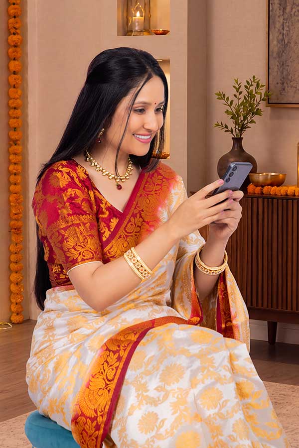 Indian woman smiling while using smartphone during Diwali celebration