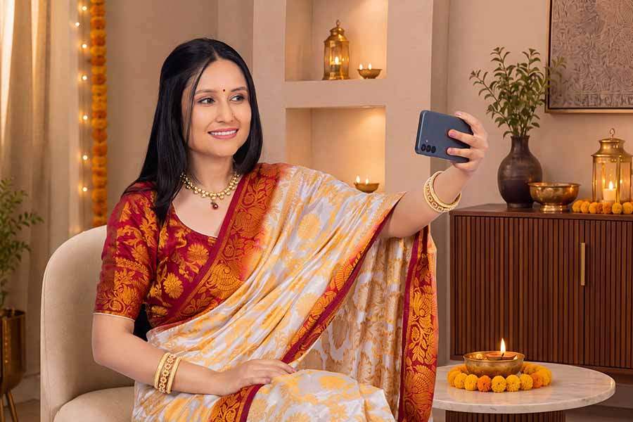 Indian woman taking selfie during Diwali celebration at home