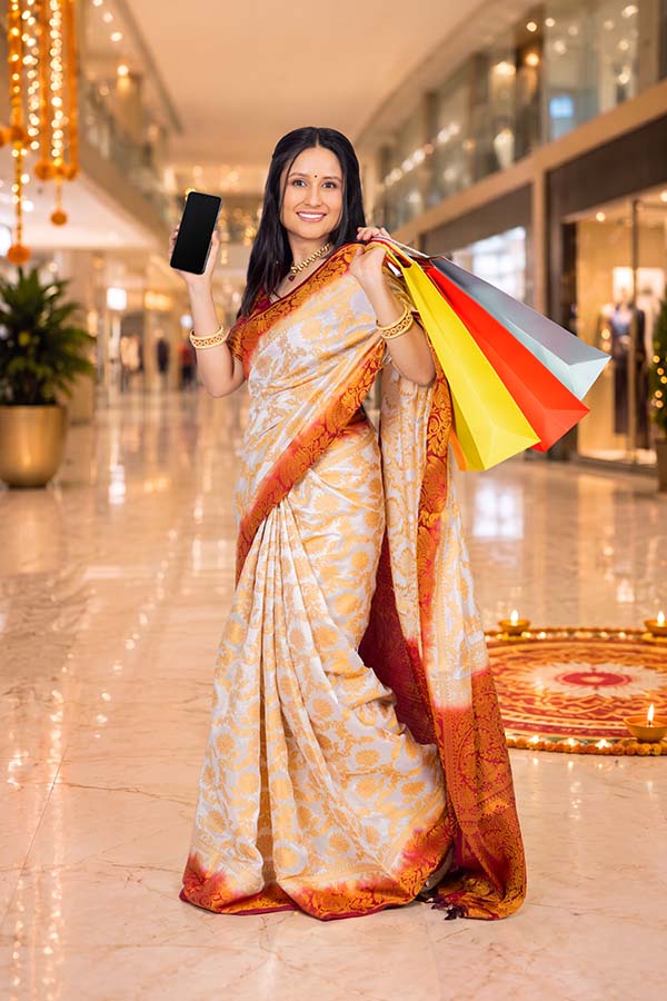 Indian woman displaying smartphone after festive shopping at mall