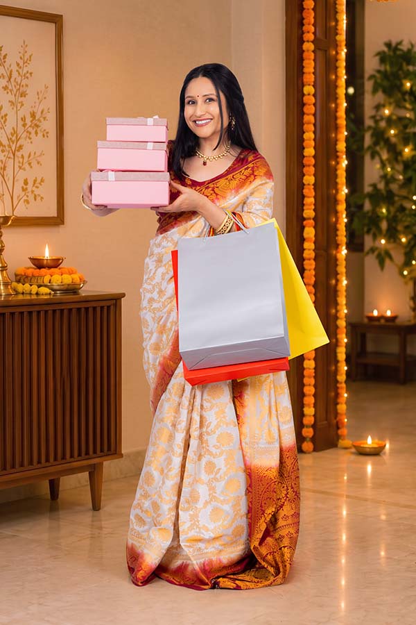 Indian woman carrying festive gift boxes and shopping bags