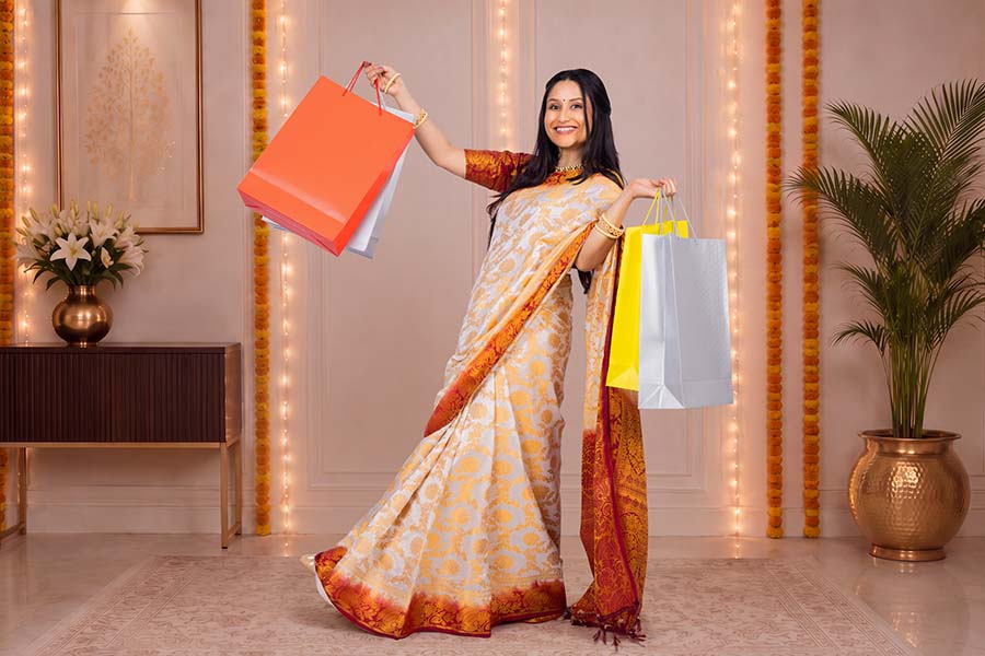 Happy Indian woman showing festive shopping bags after retail purchase