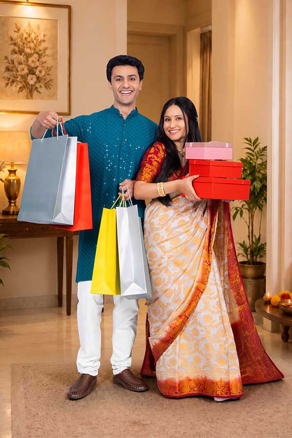 Indian couple carrying shopping bags and gift boxes during Diwali celebration