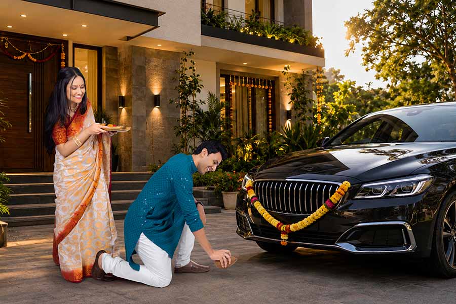 Young Indian couple performing pooja for their newly purchased car