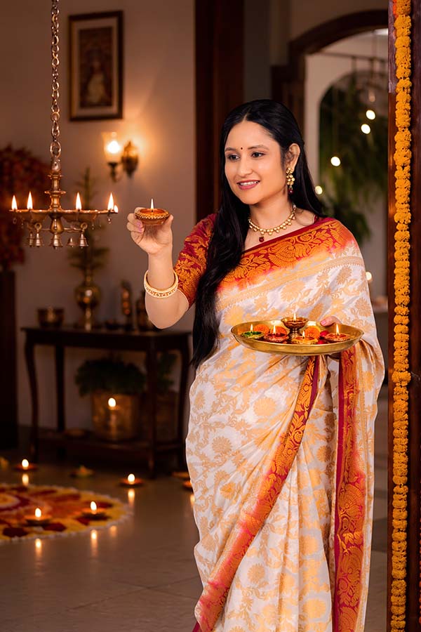 Indian woman lighting diya during festive celebration
