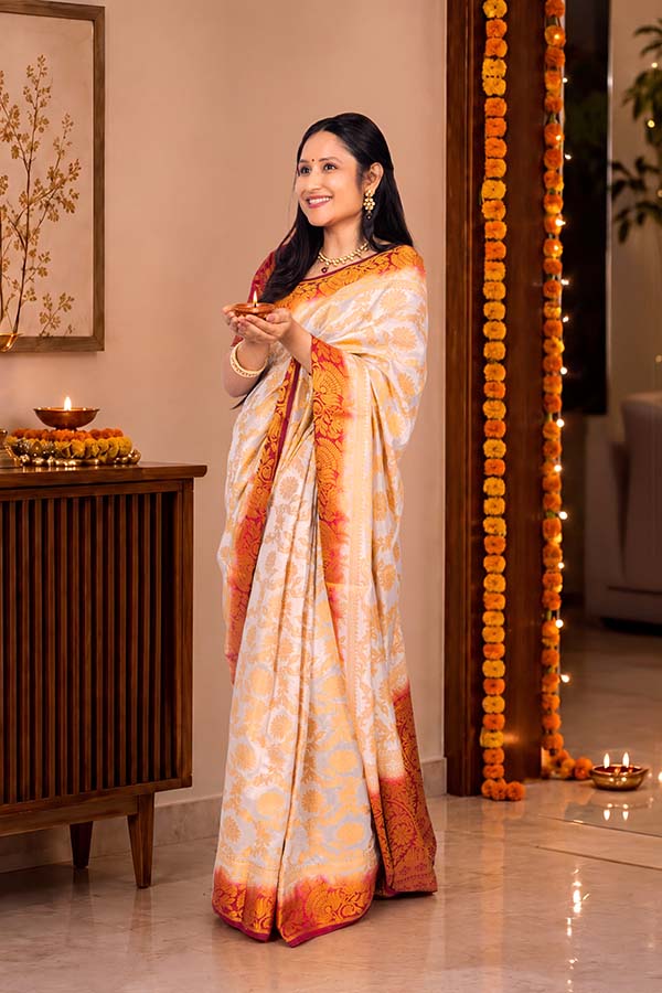 Indian woman holding illuminated diya while celebrating Diwali at home