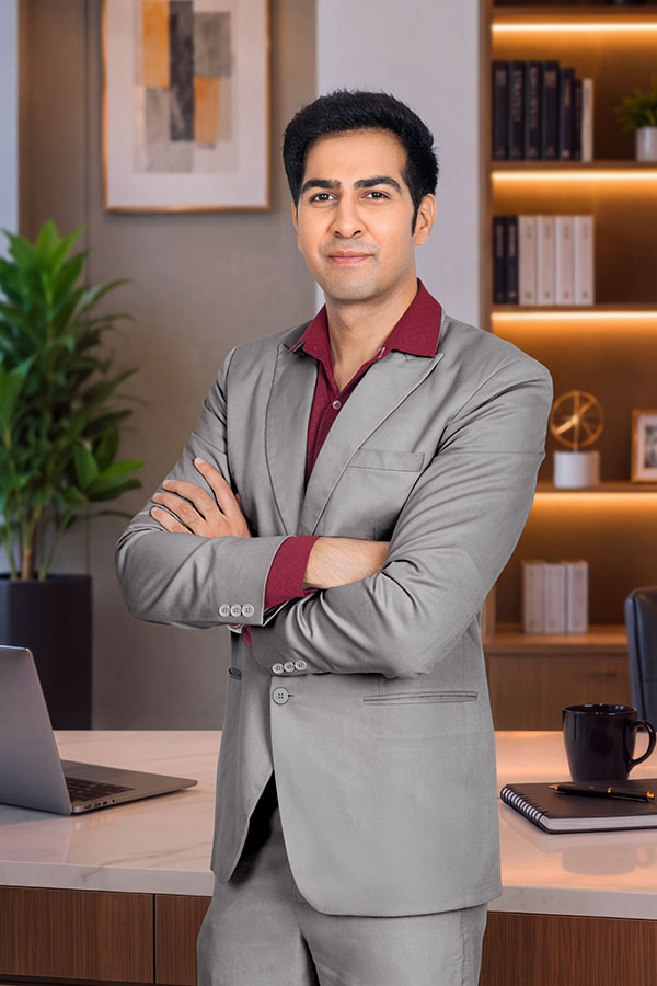 Confident Indian businessman standing with arms crossed in office