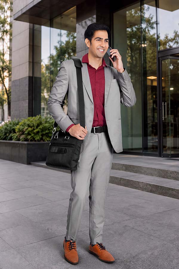 Indian businessman talking on phone outside a modern corporate building