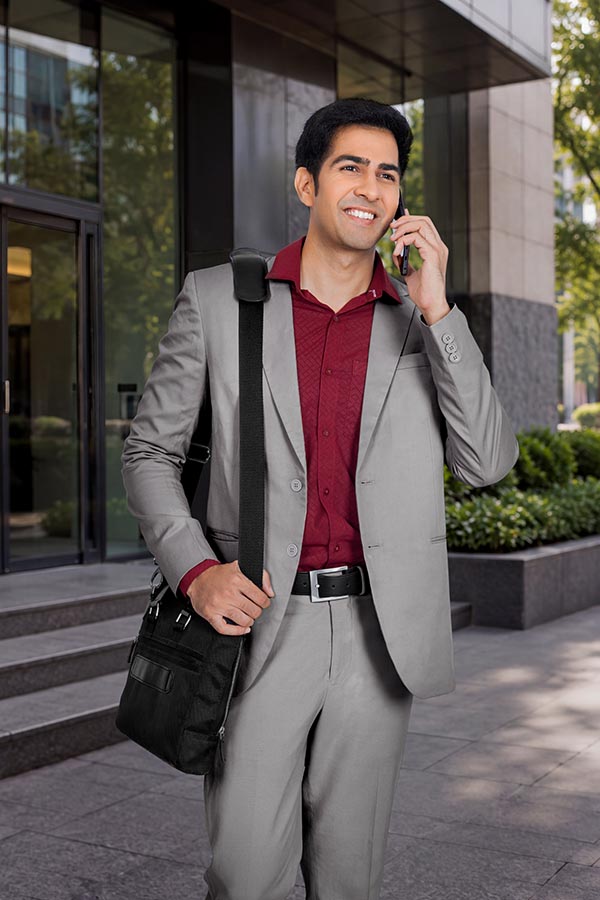 Smiling Indian businessman making a phone call outside an office