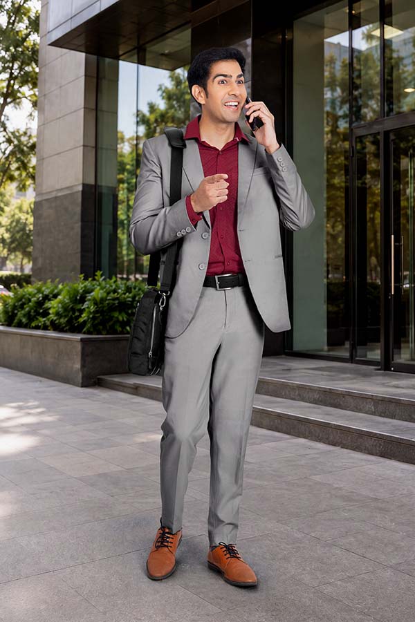 Indian businessman talking on smartphone while standing outside office
