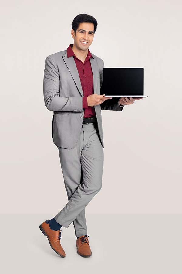 Indian businessman holding laptop in formal suit