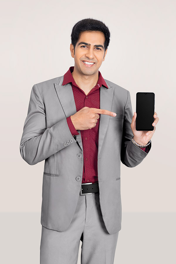 Indian businessman pointing at smartphone screen in formal suit