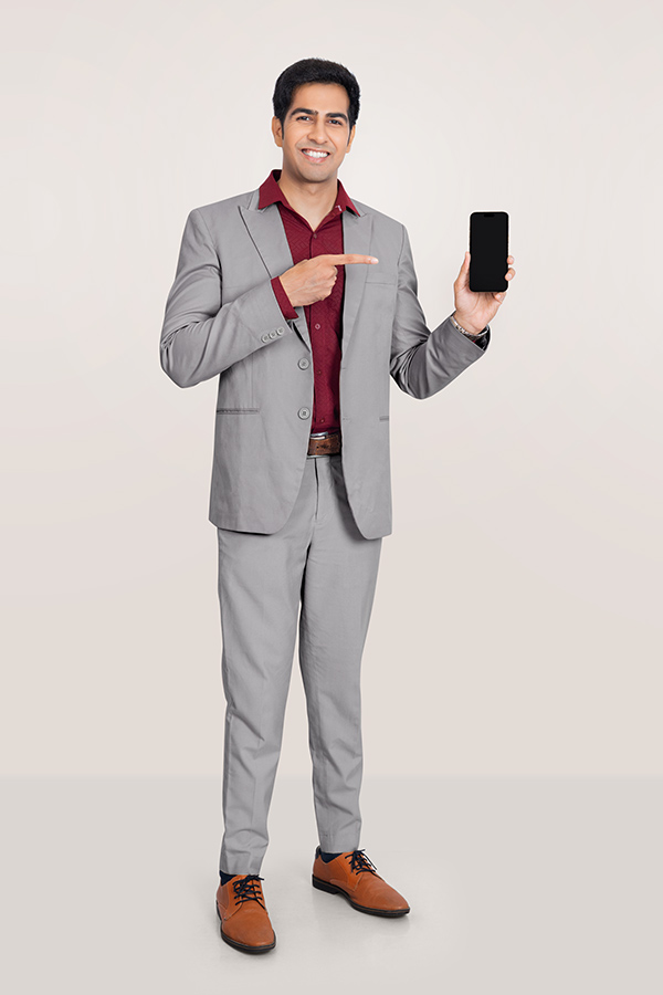 Indian businessman pointing at smartphone in formal suit