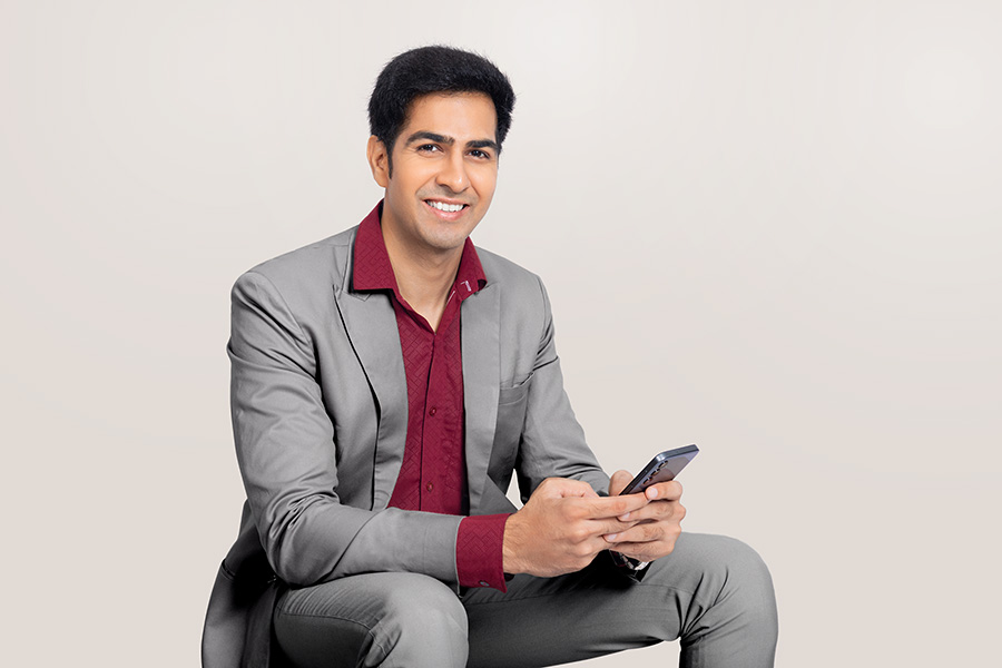 Indian businessman using smartphone while seated