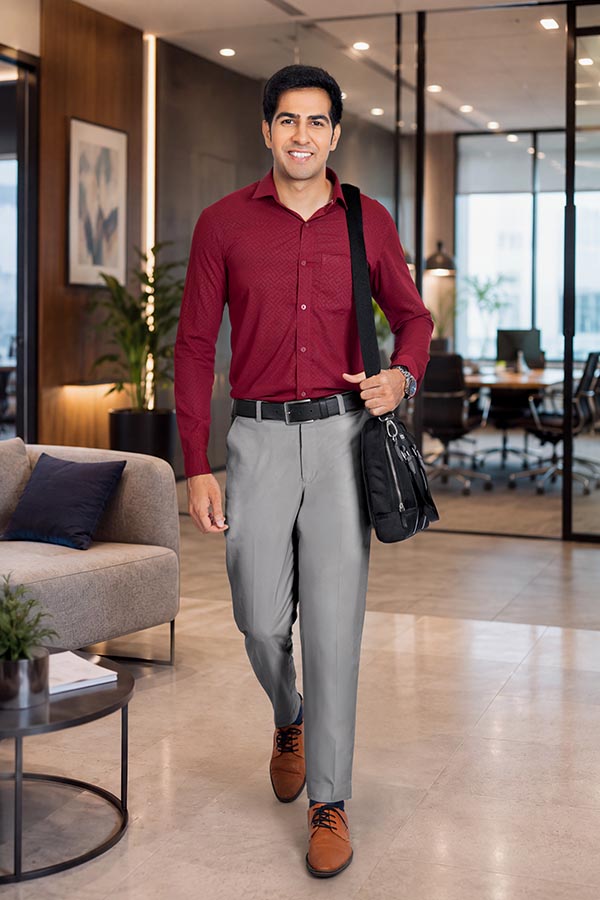 Male professional carrying shoulder bag while walking through modern office lounge