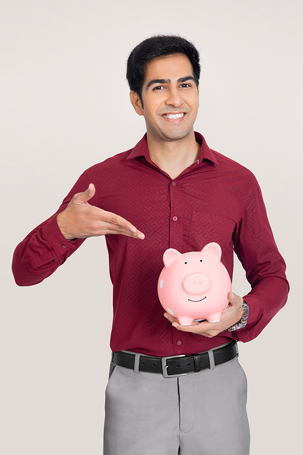 Indian businessman holding piggy bank for savings concept