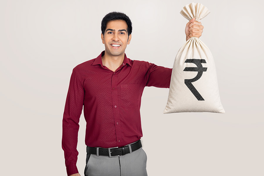 Indian businessman holding rupee money bag