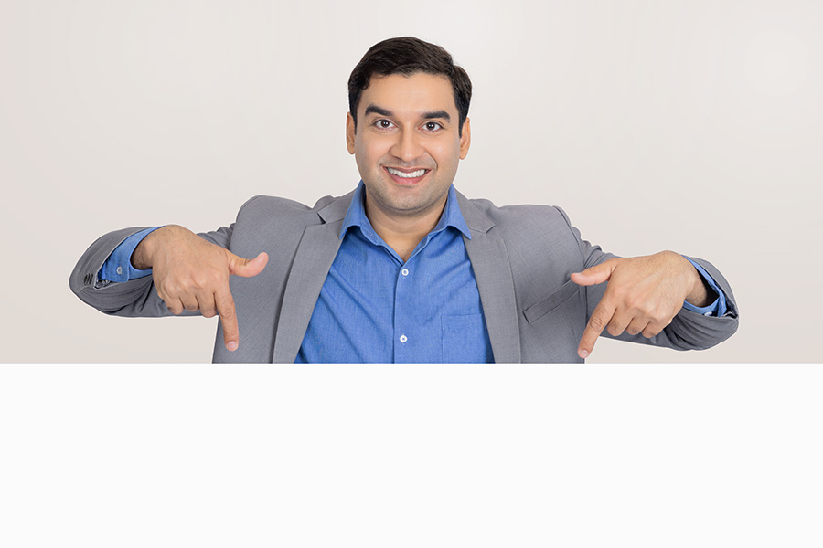 Indian businessman pointing downward with copy space