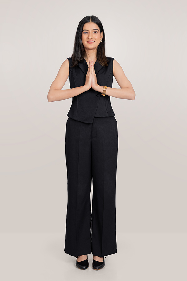 Indian businesswoman greeting with namaste gesture in formal black suit