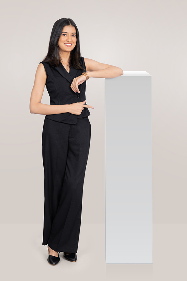 Indian businesswoman pointing toward blank display pedestal