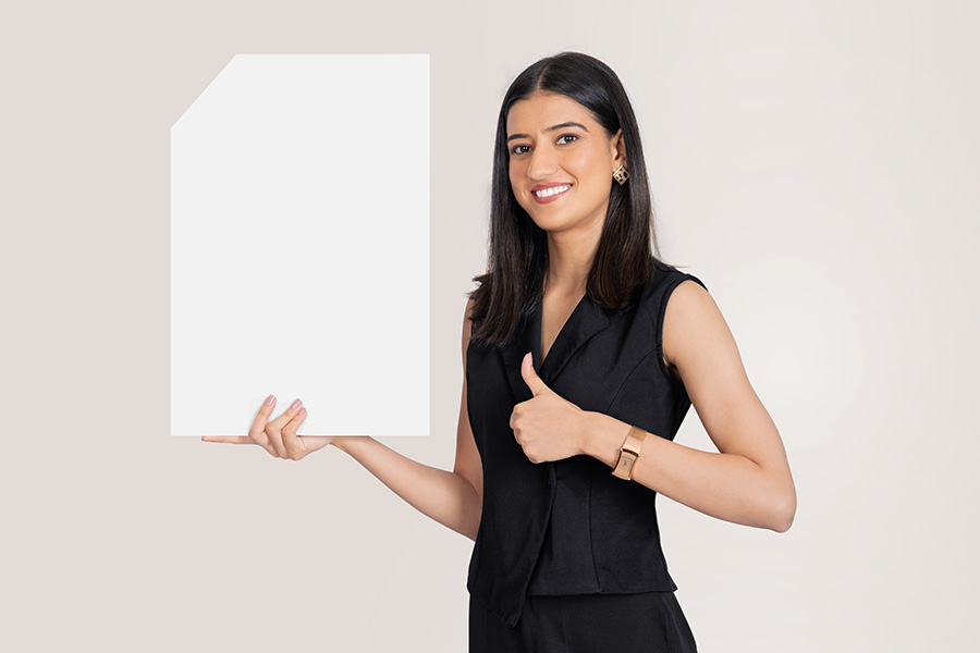 Indian businesswoman presenting blank signboard with thumbs up gesture