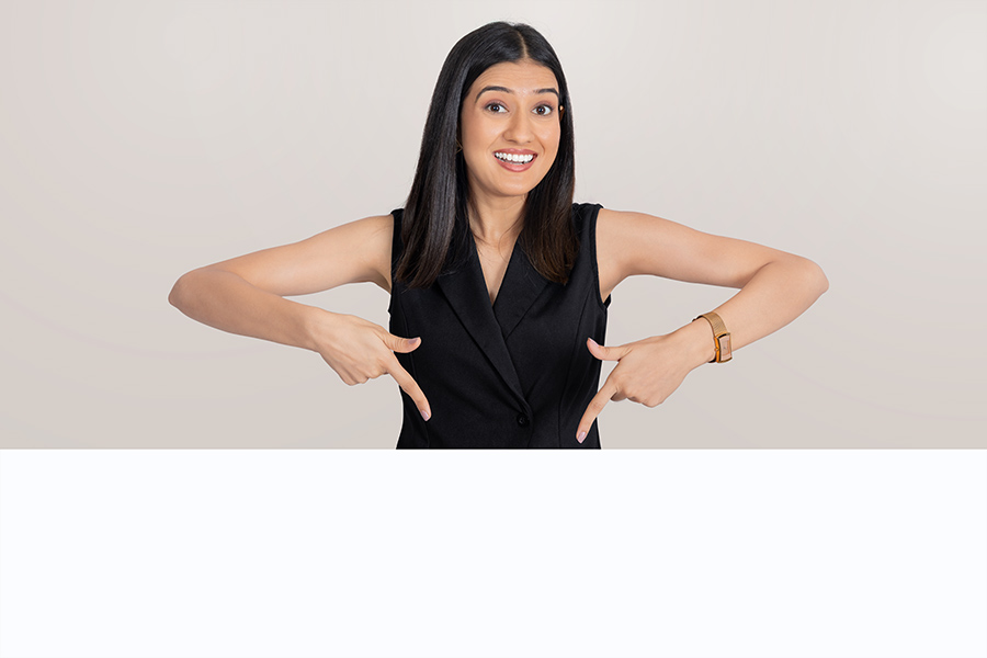 Indian businesswoman pointing downward toward copy space