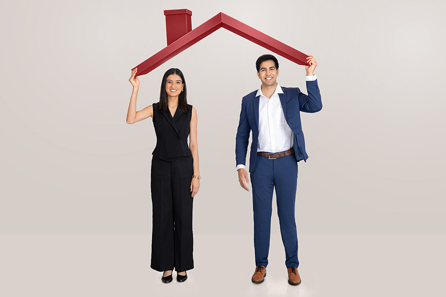 Indian business professionals holding house roof symbol for home protection concept