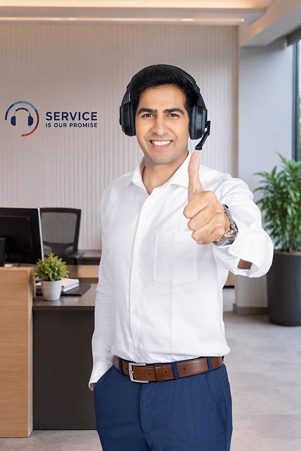 Smiling male call centre professional giving thumbs up while wearing headset