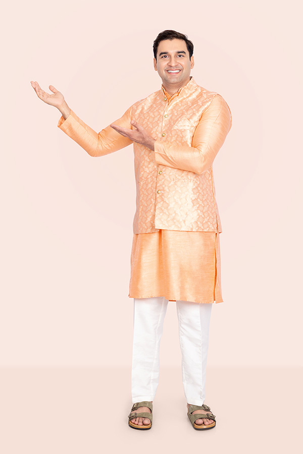 Indian man presenting copy space in a traditional peach kurta