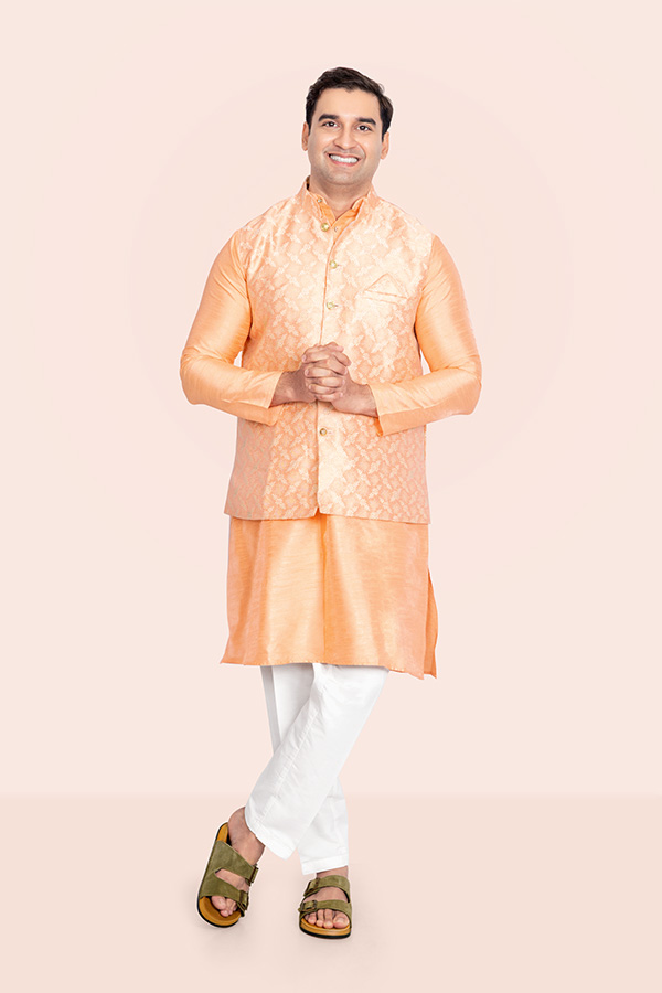 Indian man standing with clasped hands in festive traditional attire