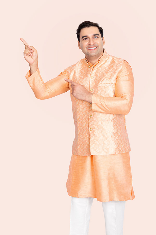Indian man pointing towards promotional copy space in traditional attire