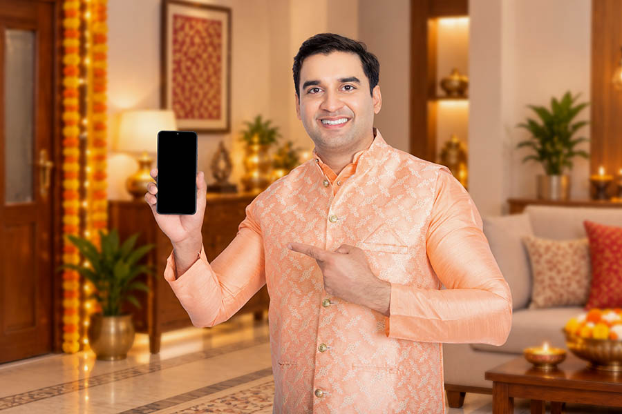 Indian man presenting a smartphone in a festive home