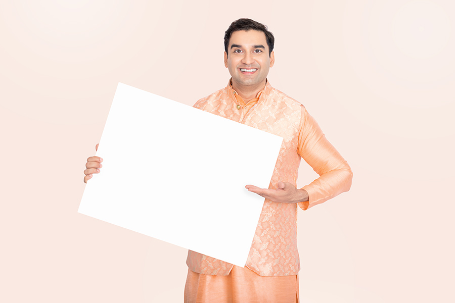 Indian man presenting an angled blank signboard for advertising