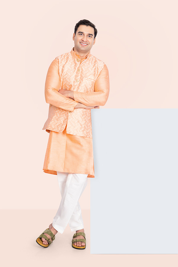 Confident Indian man standing with folded arms beside a blank panel