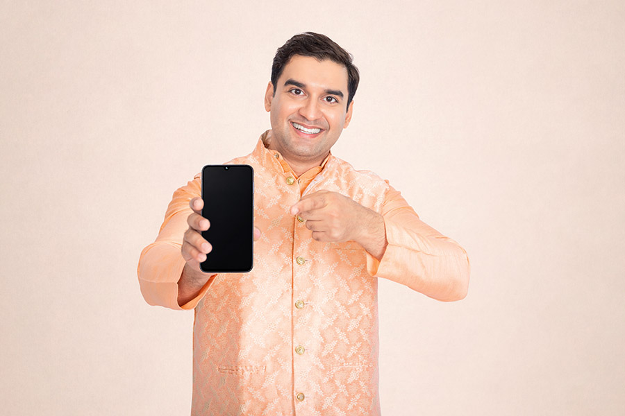 Indian man pointing at a smartphone with a blank screen