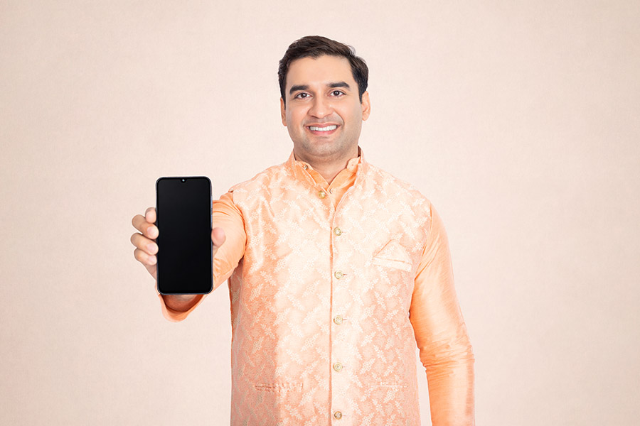 Indian man presenting a smartphone with an empty screen