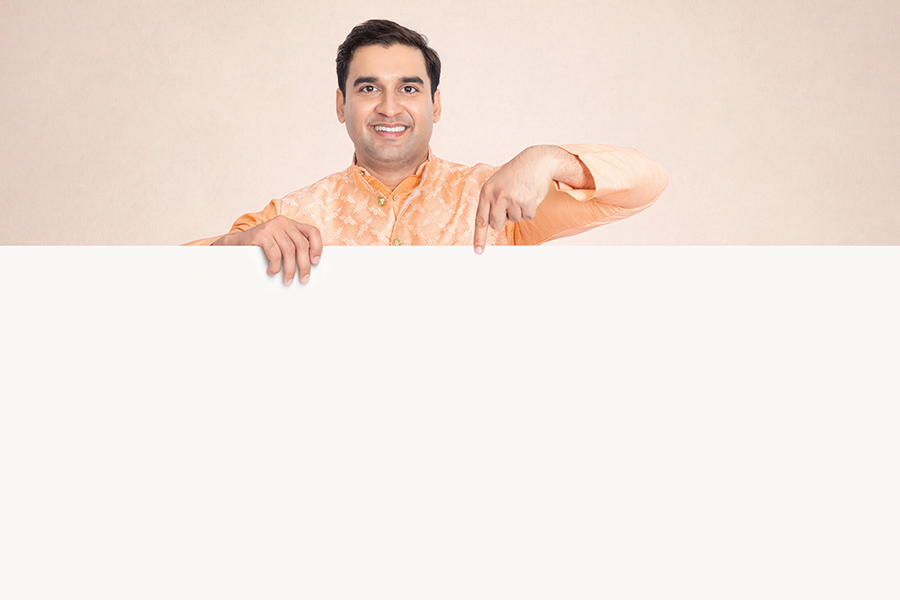 Indian man pointing down at blank advertising space